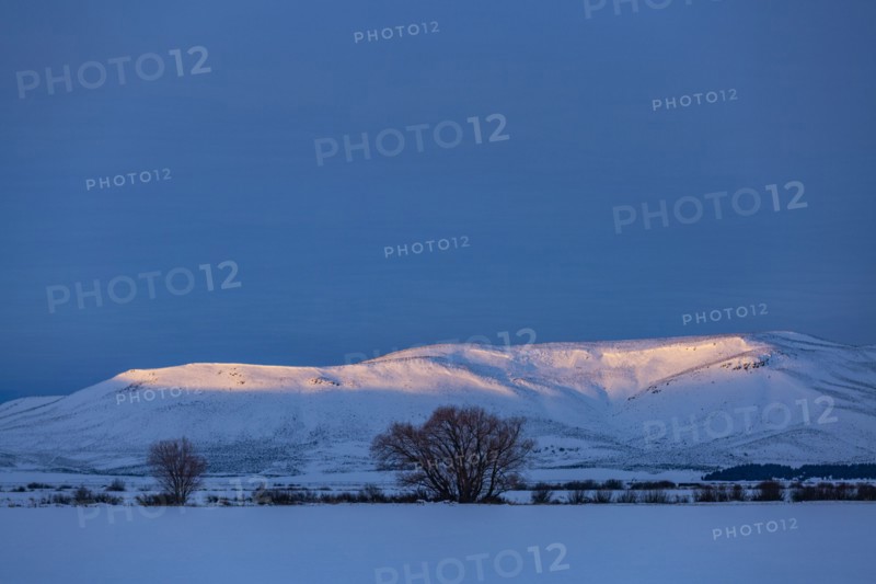 USA, Idaho, Bellevue, Snow covered field and hills at sunrise