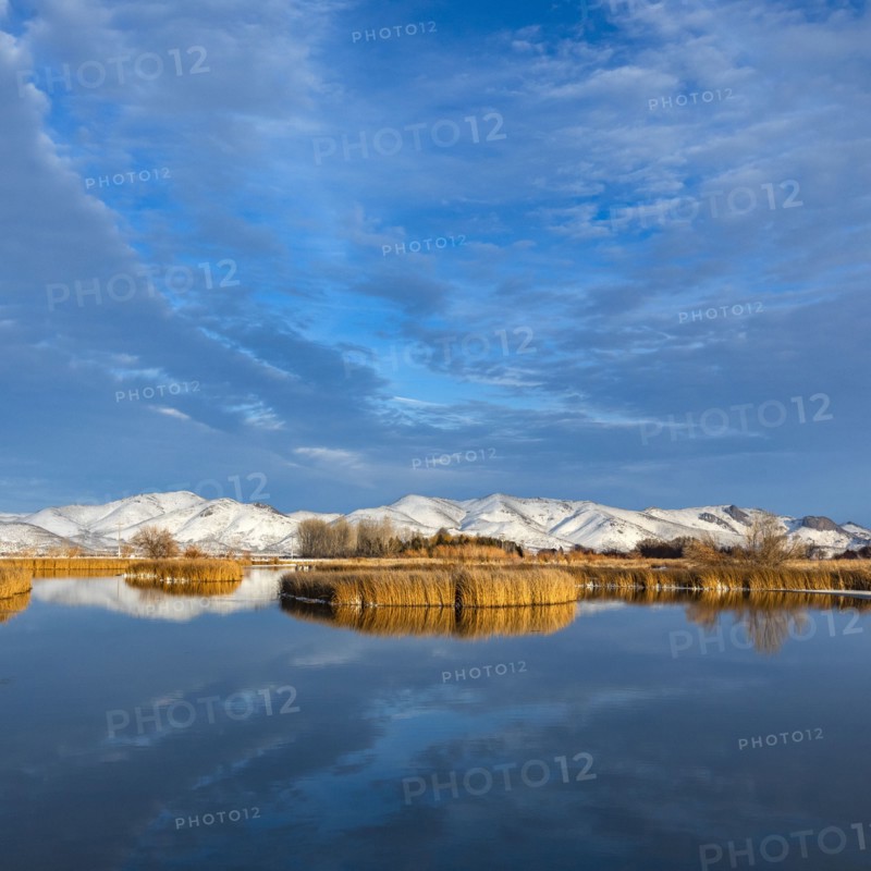 Calm river with snow covered hills in background