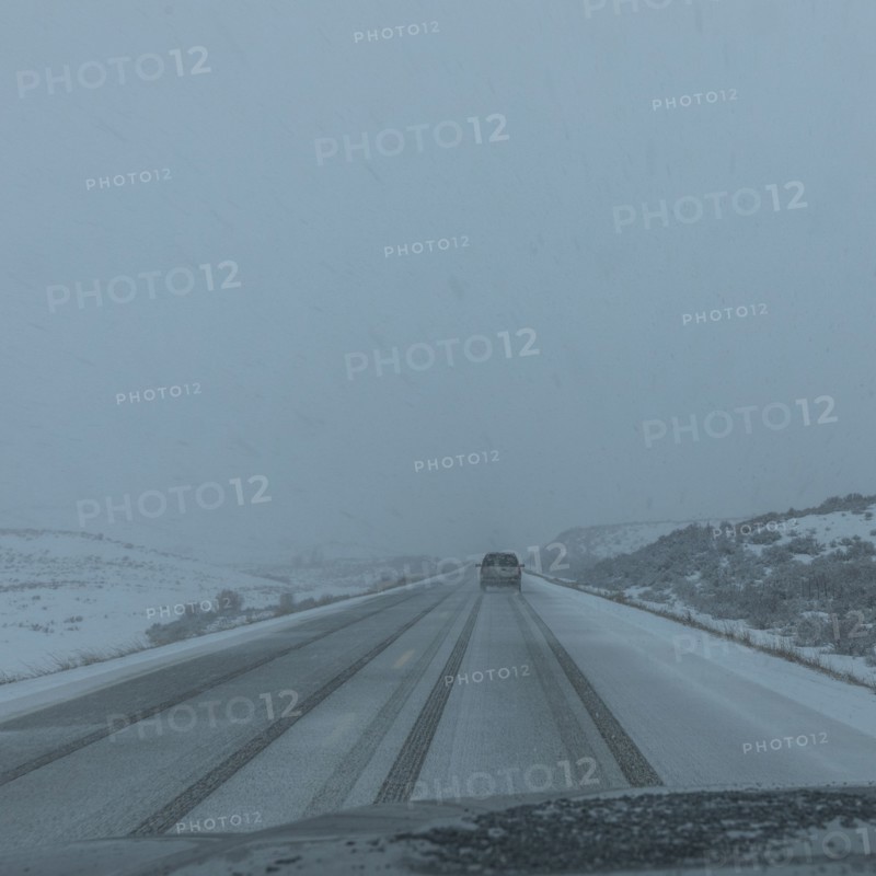 Snow covered rural road seen from car