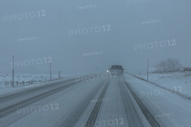 Pick-up truck on snow covered highway 20 in rural landscape
