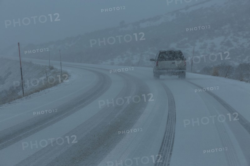 Pick-up truck on snow covered highway 20 in rural landscape