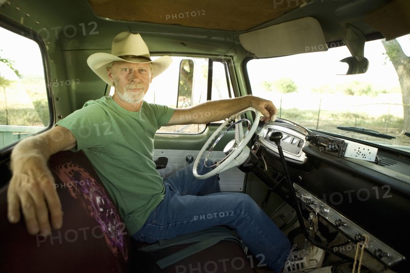 Man wearing cowboy hat in pick-up truck