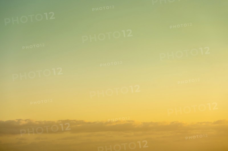 Golden sky at sunrise with low clouds below