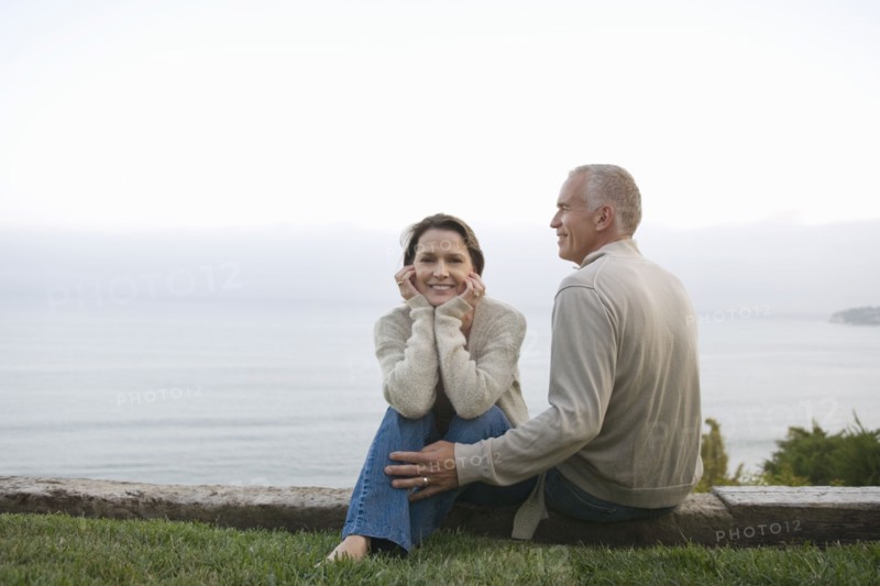 Mature couple sitting on coast