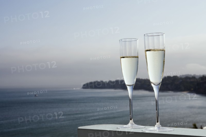 Two glasses of champagne with sea in background