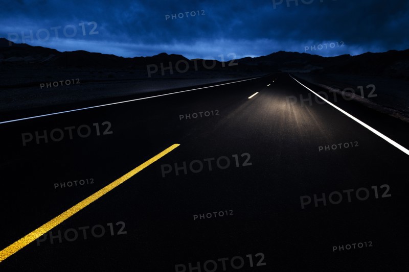 Empty highway at night with car headlights
