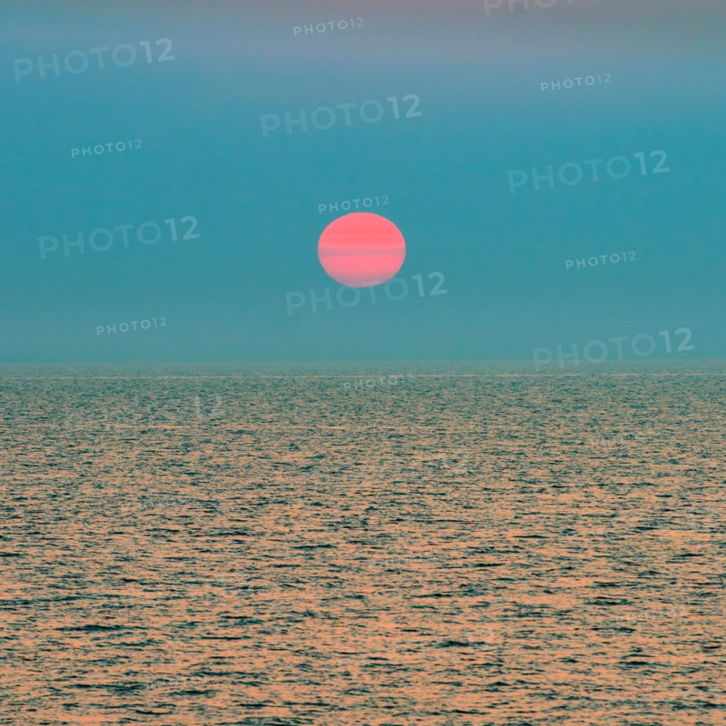 Red setting sun over ocean