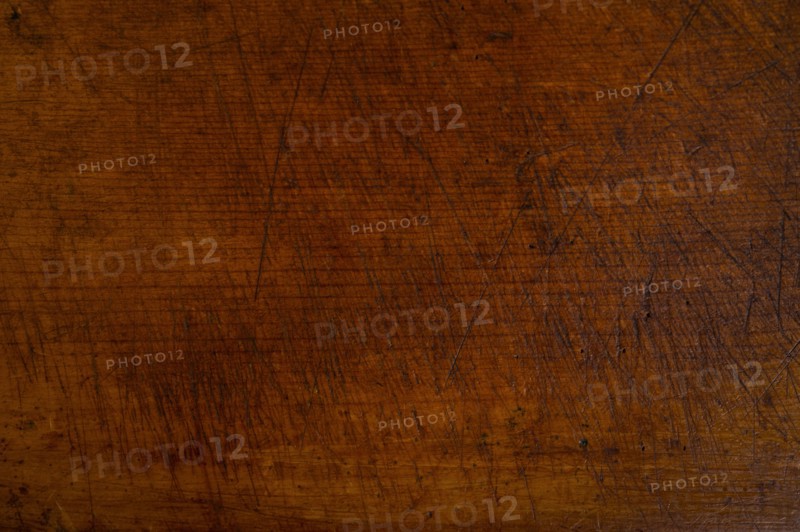 Close-up of worn antique cutting board with knife cut marks