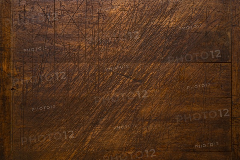 Close-up of worn antique cutting board with knife cut marks