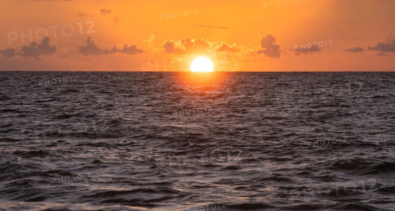 Sun rising over ocean
