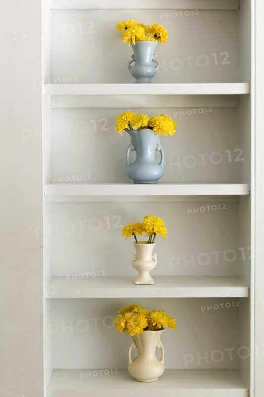 Shelf with vases and yellow flowers