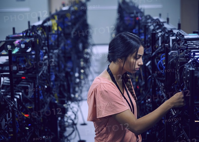 Female technician working in server room