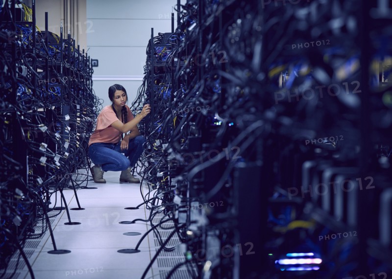 Female technician working in server room