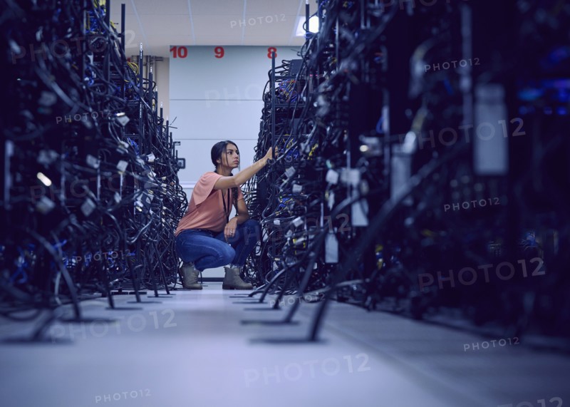 Female technician working in server room