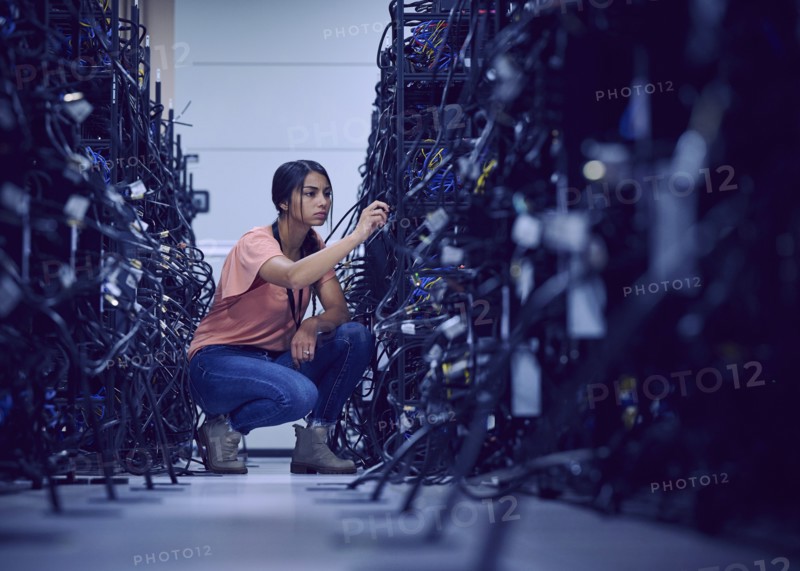 Female technician working in server room