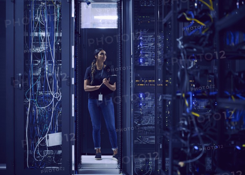 Female technician working in server room