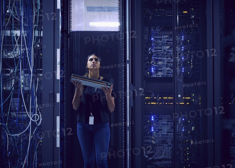 Female technician carrying hard drive in server room