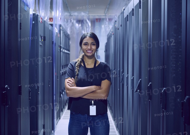 Portrait of smiling female technician standing in server room