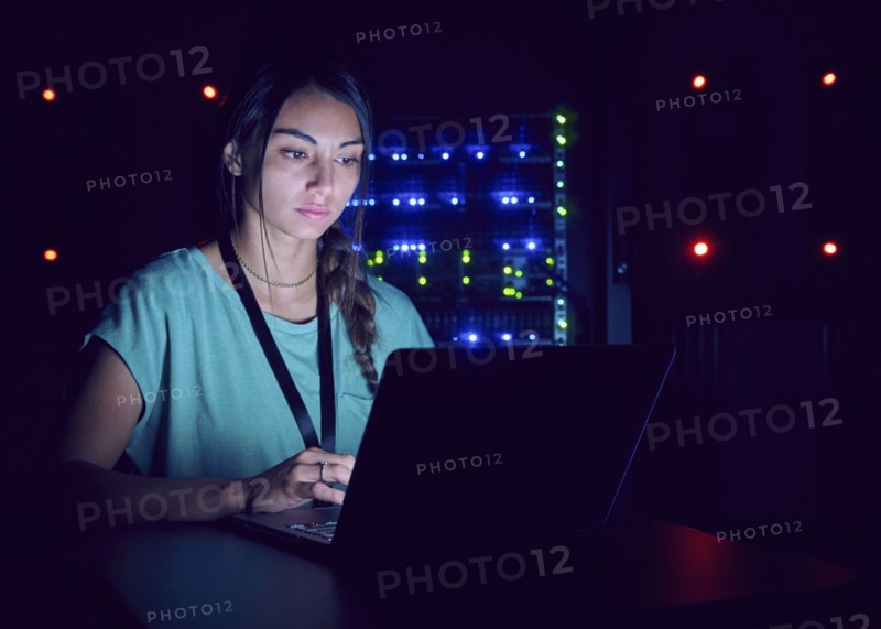 Technician using laptop in server room