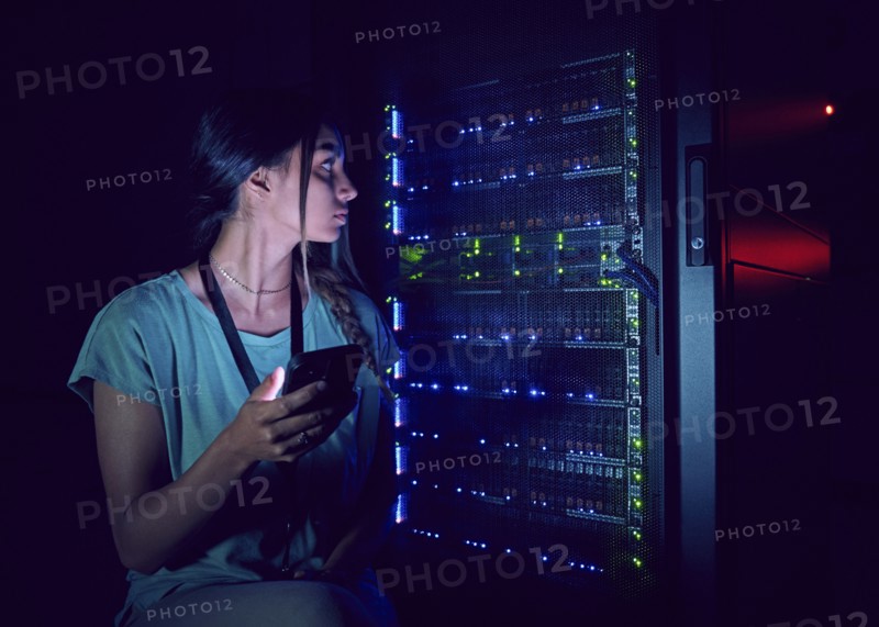 Technician with smart phone in server room
