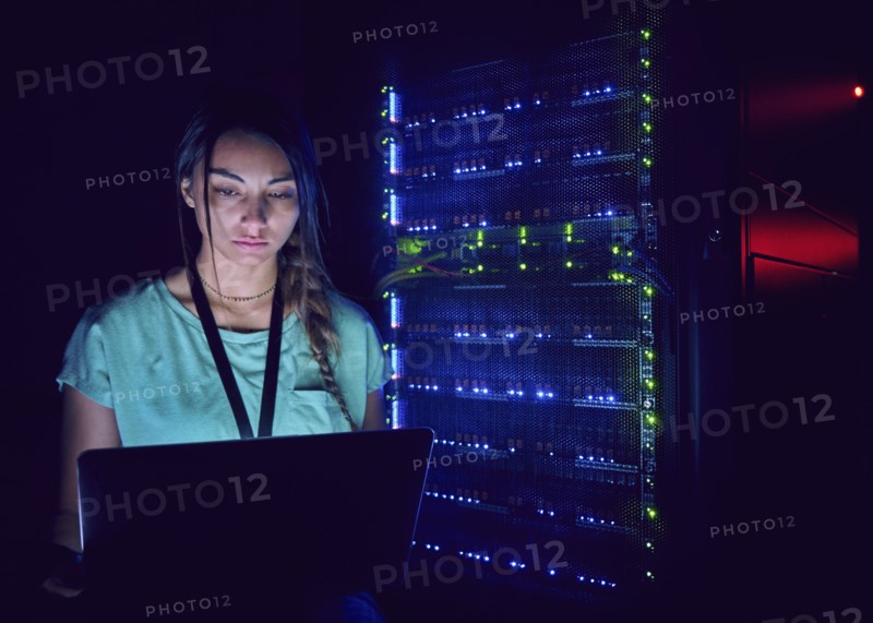 Technician using laptop in server room