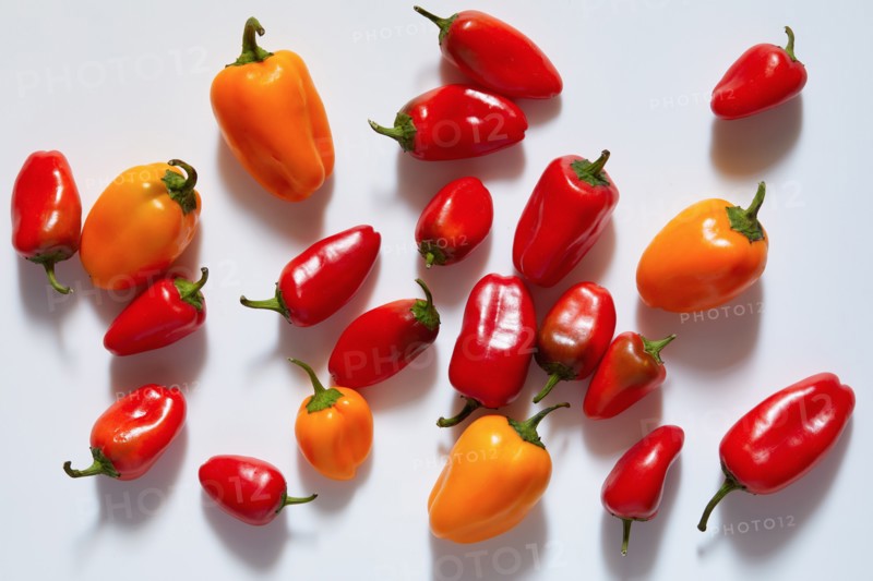 Red and orange peppers on white background