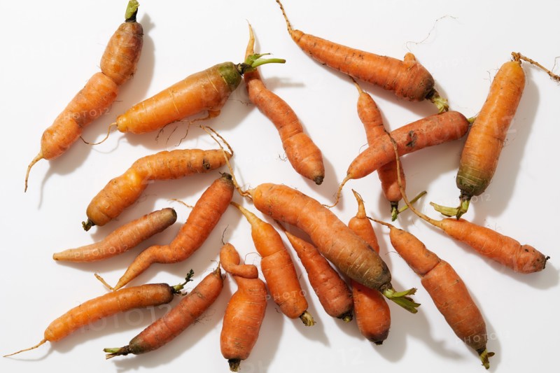 Overhead view of fresh carrots on white background
