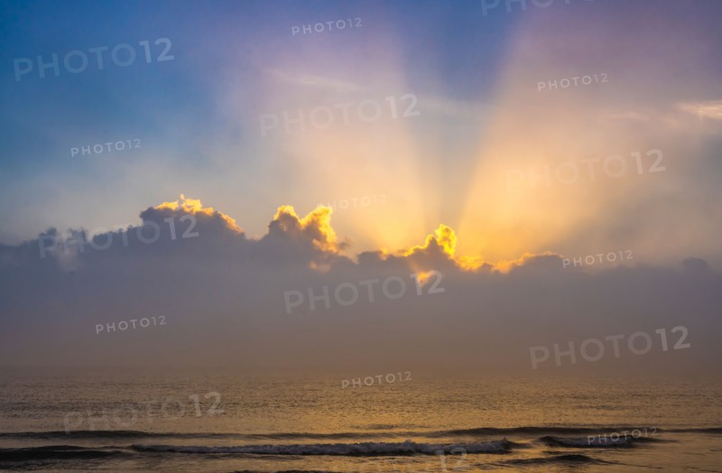 Sun rising above calm ocean