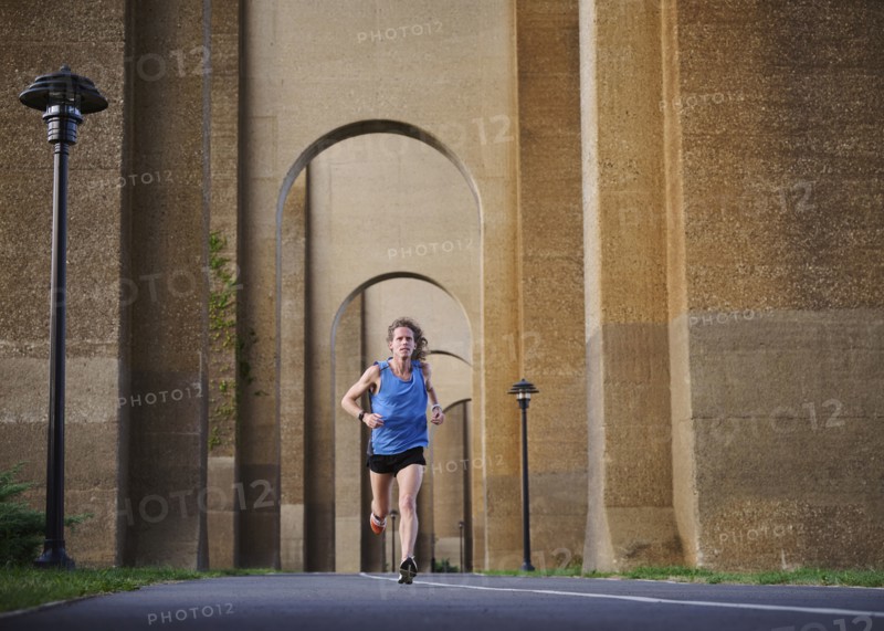 Man jogging under bridge