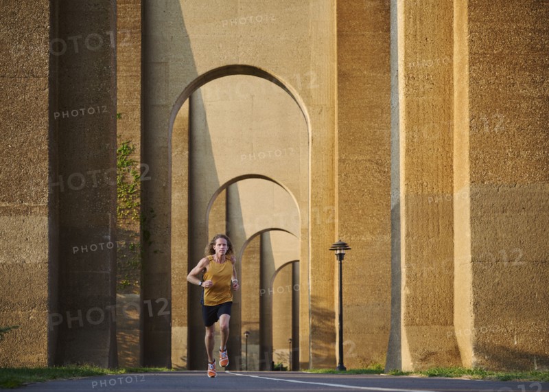 Man jogging under bridge