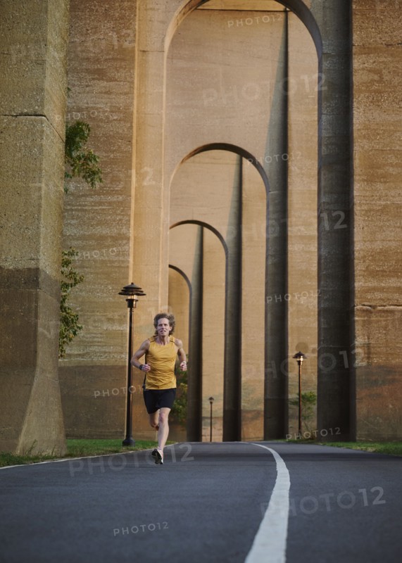 Man jogging under bridge