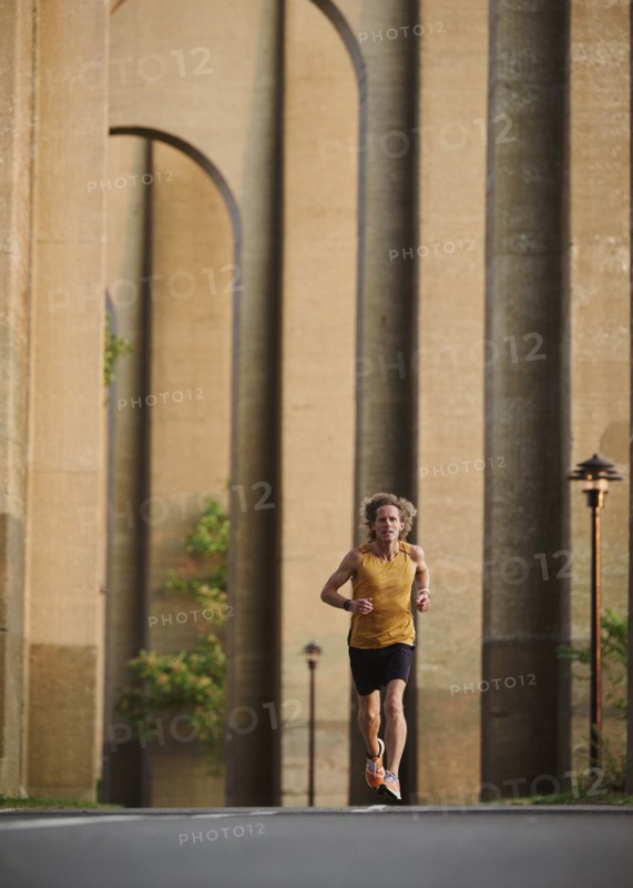 Man jogging under bridge