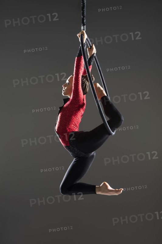 Young acrobat performing on aerial hoop