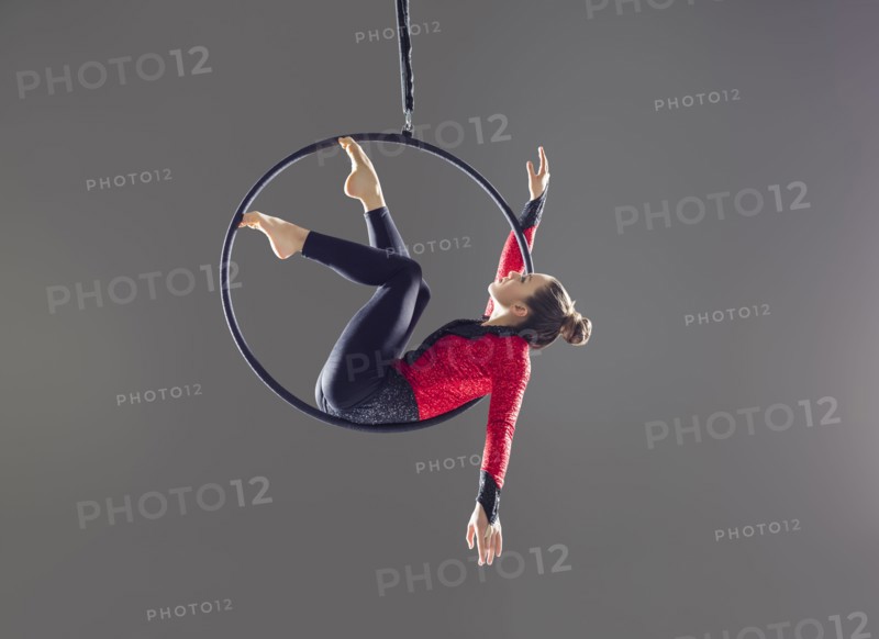 Young acrobat performing on aerial hoop