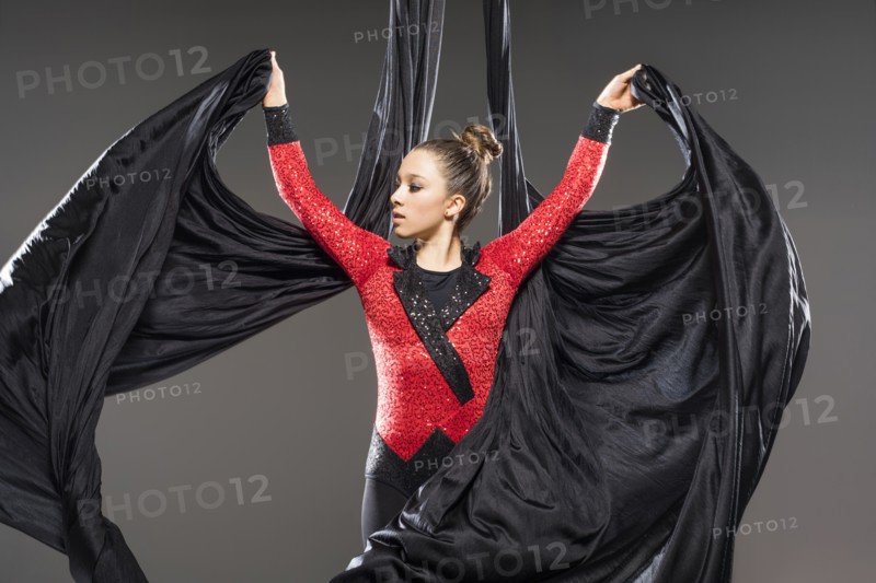 Young acrobat performing with aerial silks