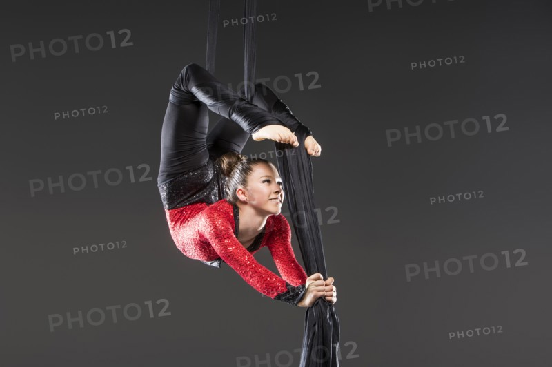 Young acrobat performing on aerial silks