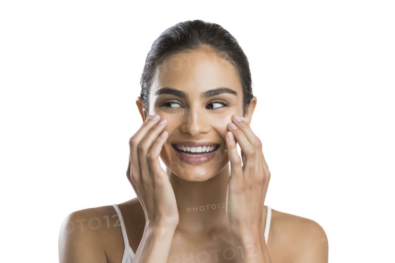 Portrait of young woman doing face massage