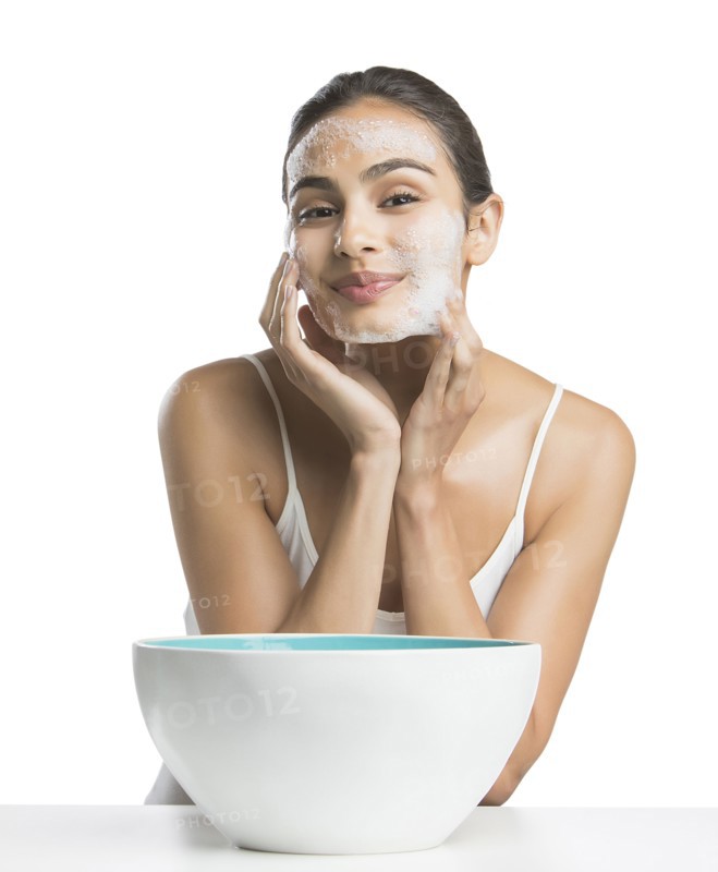 Portrait of young woman enjoying washing face