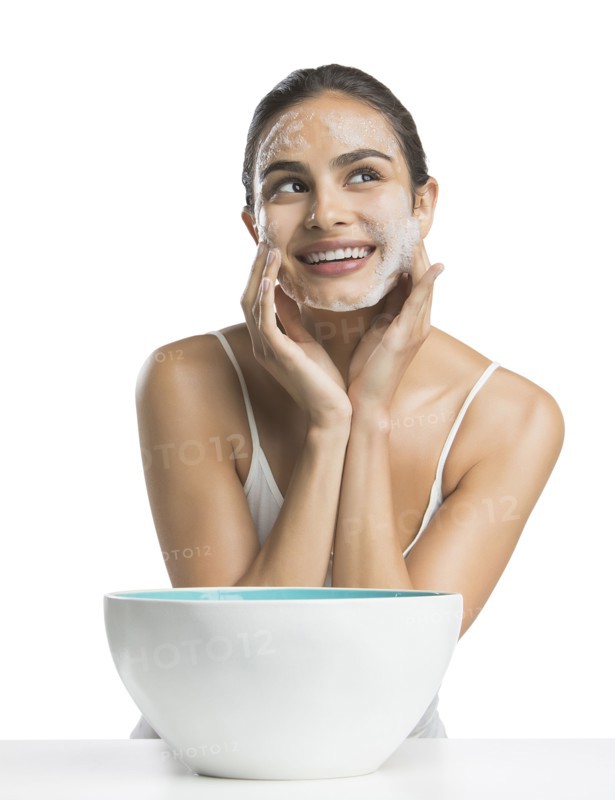 Portrait of young woman enjoying washing face