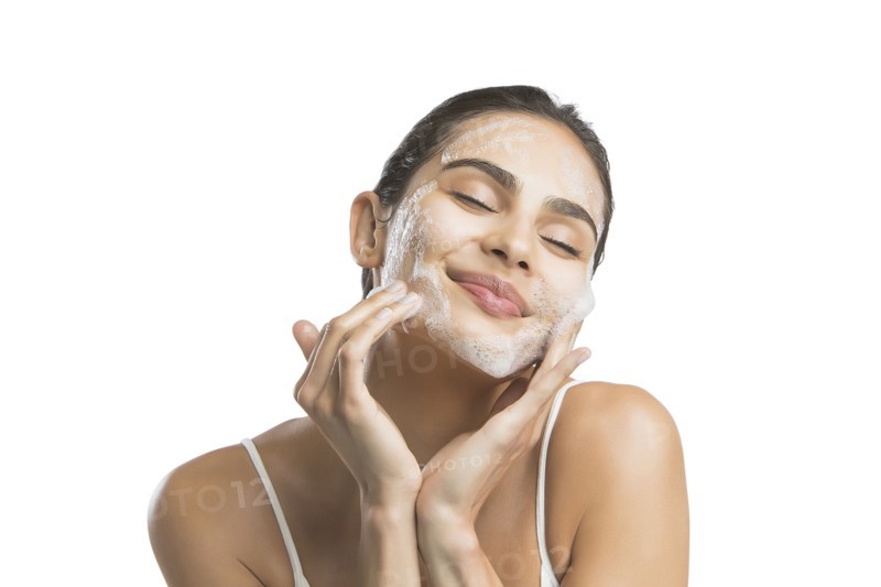 Portrait of young woman enjoying washing face