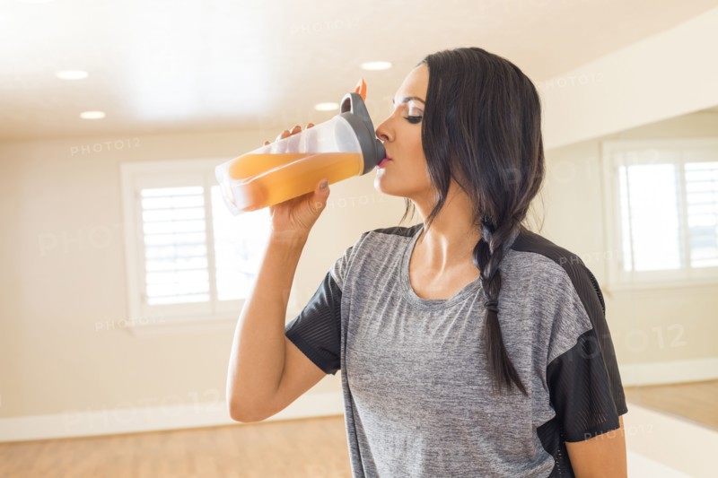 Woman resting and drinking in dance studio