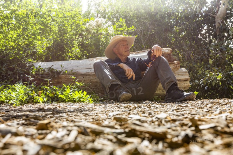 Senior man resting next to fallen tree