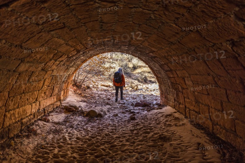 Female hiker walking through tunnel