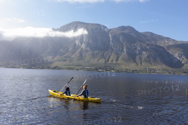 Boy and teenage girl kayaking in lagoon