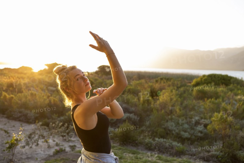 Teenage girl dancing at sunset