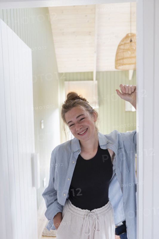 Portrait of teenage girl standing in doorway and smiling