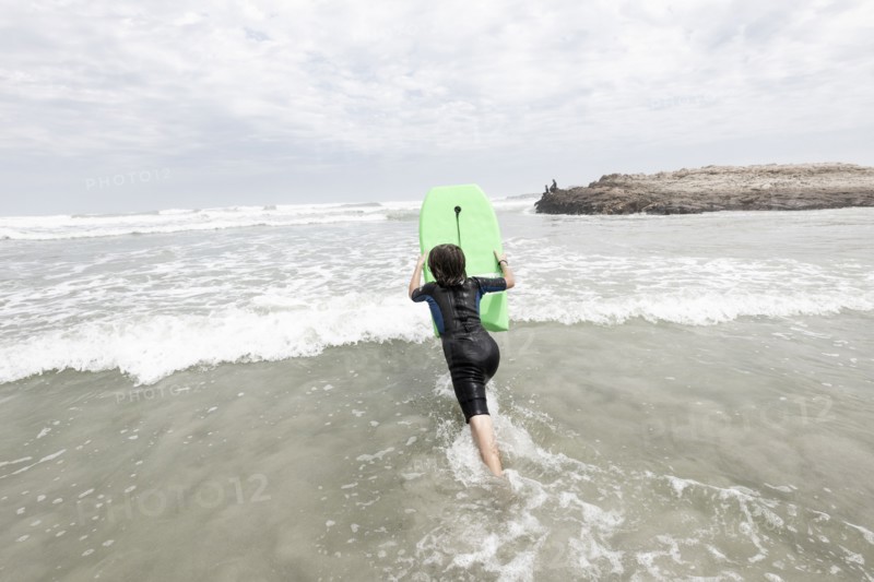 Boy bodyboarding on Voelklip beach