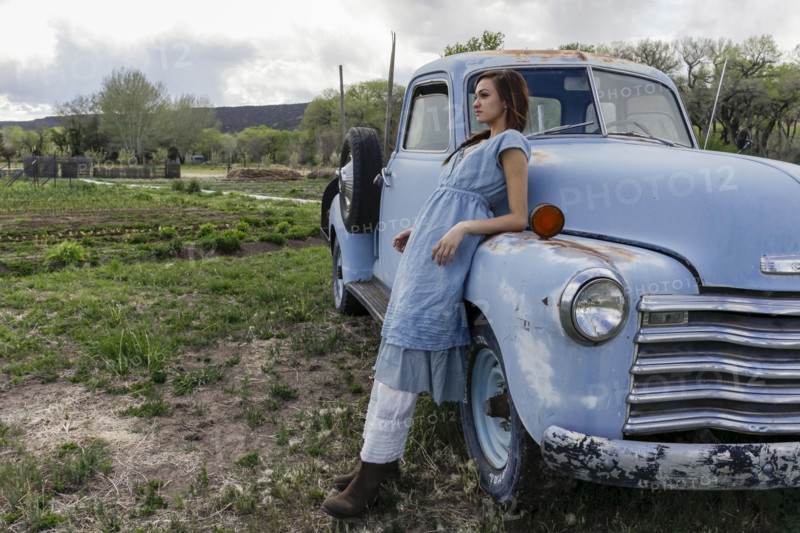 Young woman leaning on vintage car
