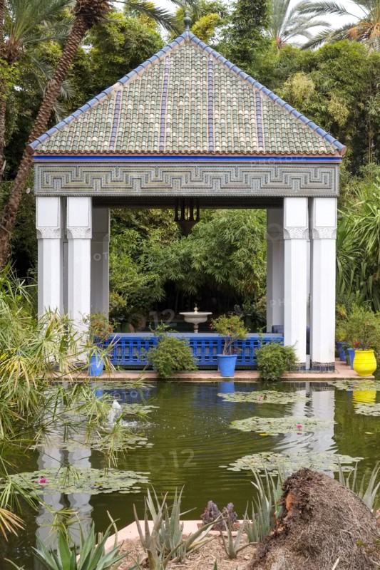 Moroccan tiles roof atop gazebo by tranquil pond