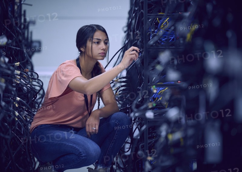 Female technician working in server room
